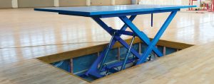 blue scissor lift coming out of the floor