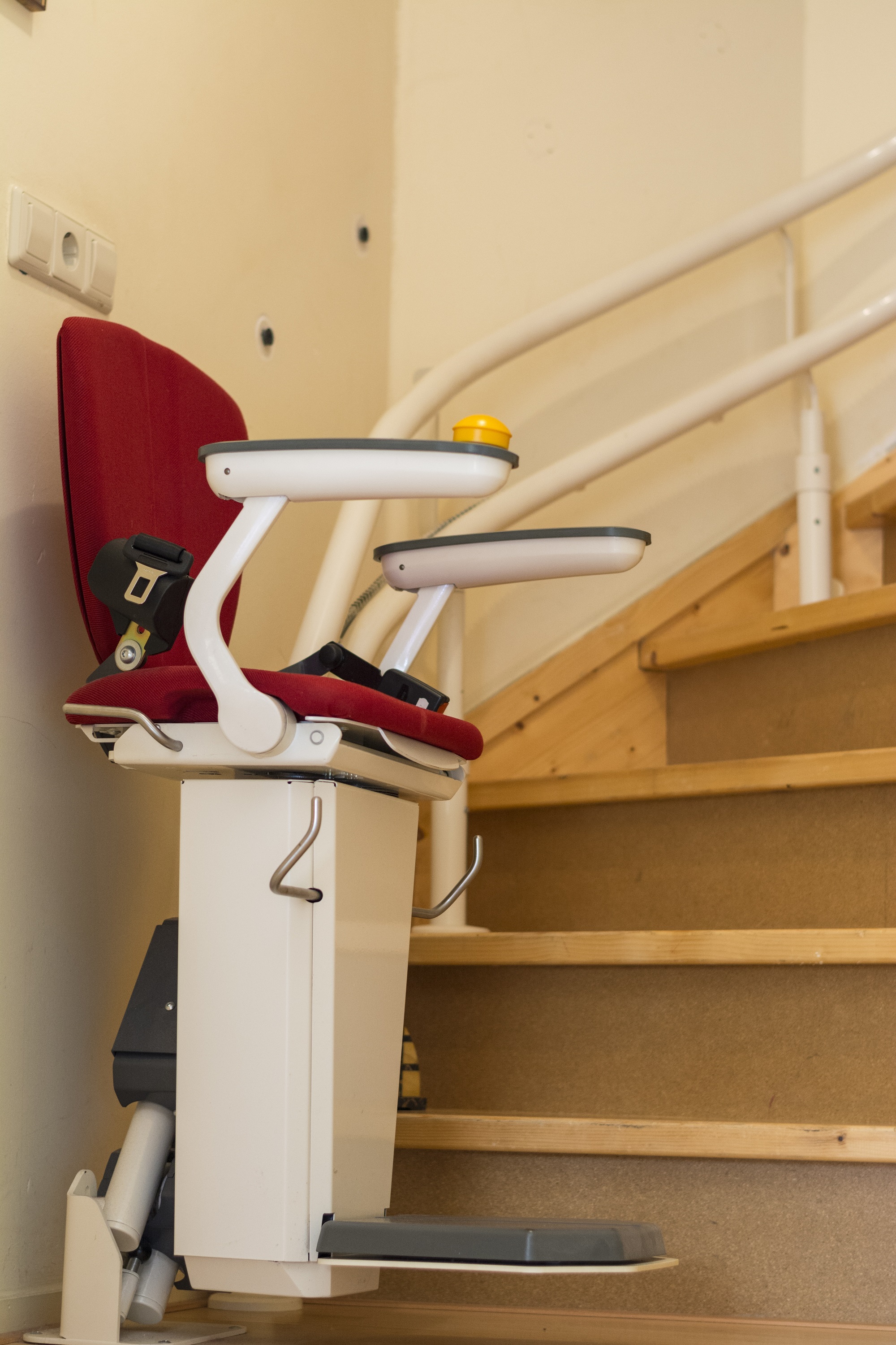 red cushion stair lift at the bottom of stairs