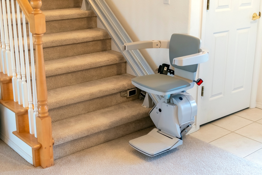A stair lift at the bottom of a staircase.